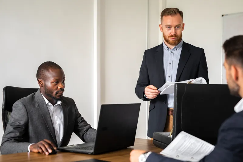 Attorneys and clients across a conference table reviewing documents