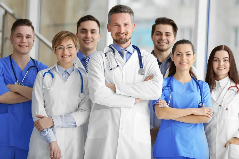 Group practice physicians and clinical staff together in a hallway