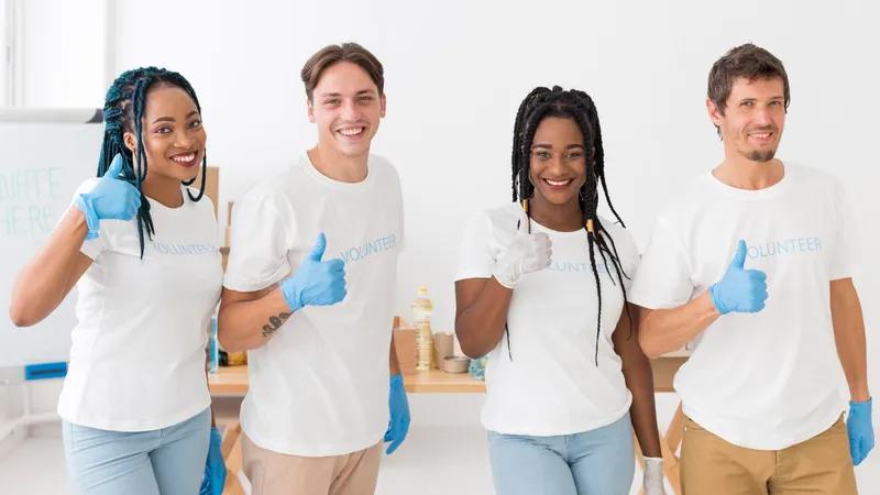 Four volunteers in matching shirts giving a thumbs up